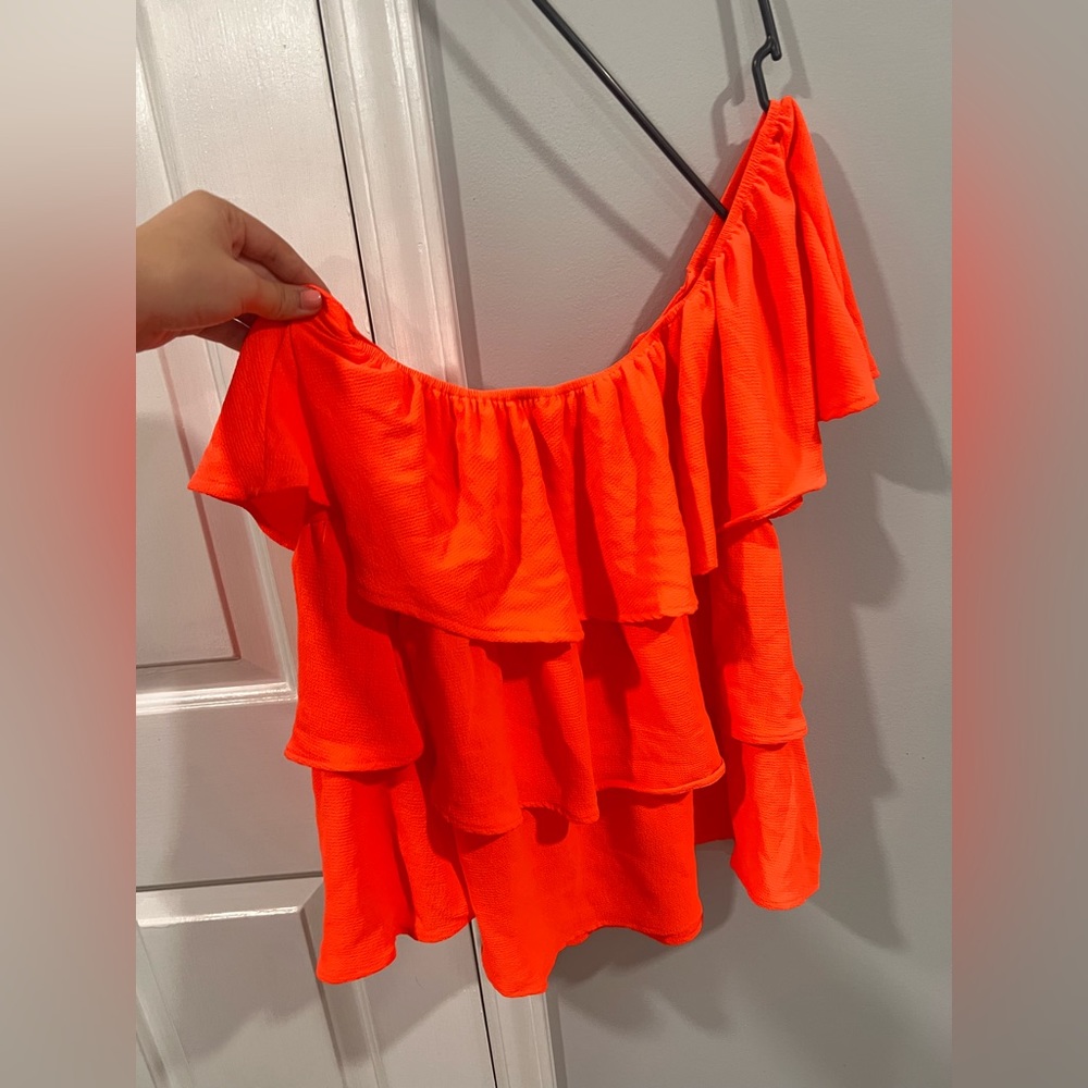 Bright peach colored one shoulder ruffle top